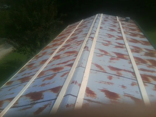 Rusted metal roof panels with new wood purlins before replacement — Storm Damage Roof Repair in Somers by Roofing Brothers
